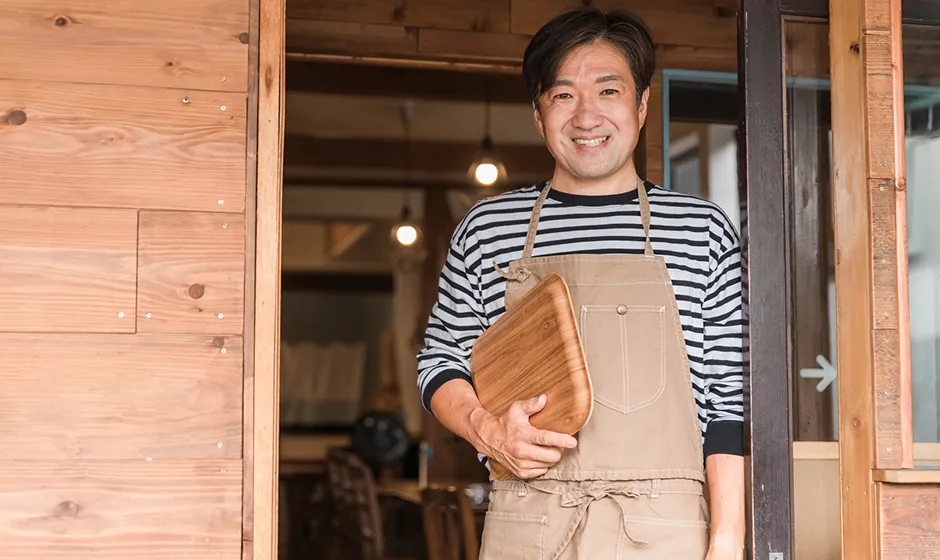 店舗の前に立つオーナー